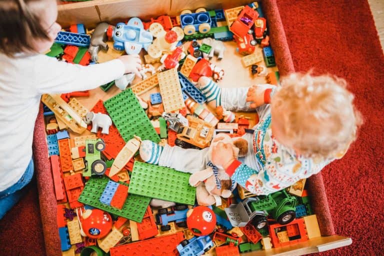 Kinder spielen in einer Kiste, die gefüllt ist mit Lego